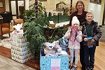 Waldo State Bank employee with family next to Project Angel Hugs donations.