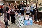Waldo State Bank employees posing with their donations to Project Angel Hugs in the bank lobby.