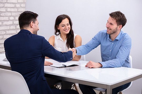 A loan officer works with a business team on financing a project